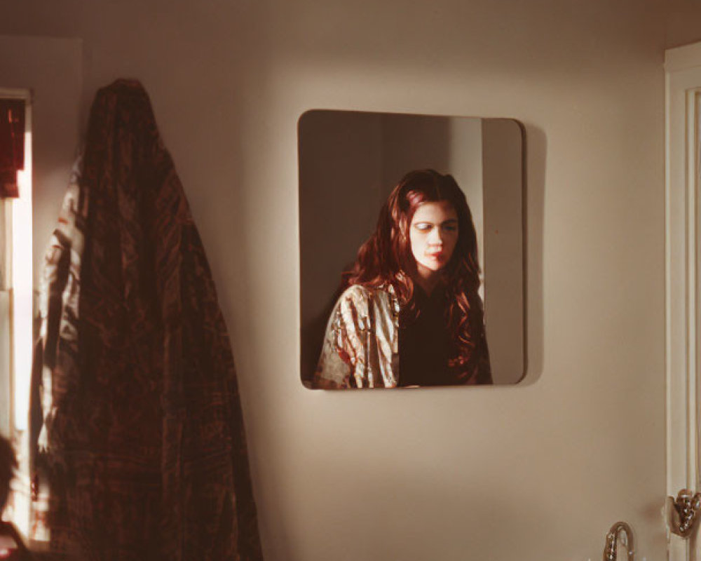 Woman's Reflection in Bathroom Mirror with Coat Nearby