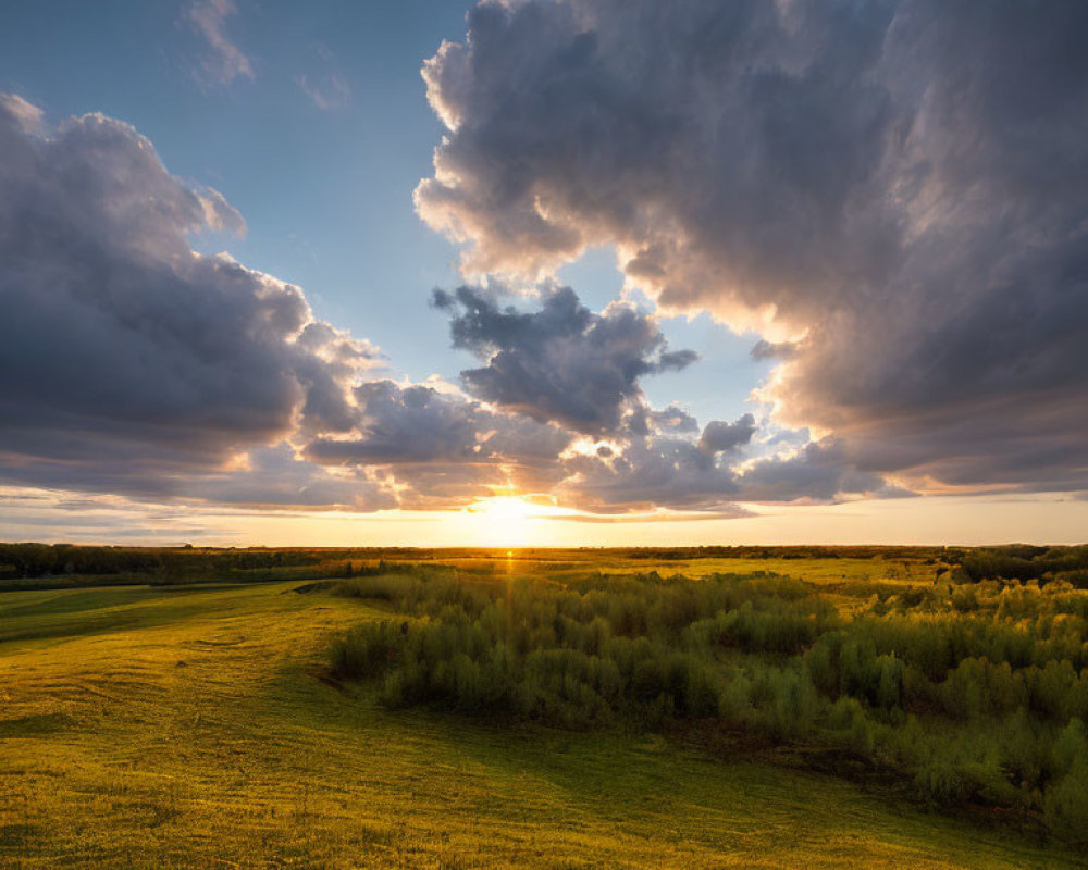 Dramatic Sunset Over Green Field and Dark Clouds