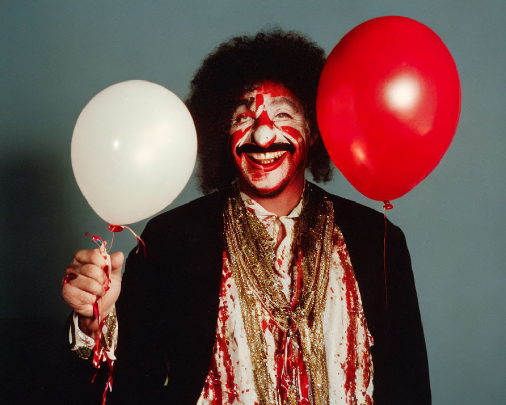 Clown with painted face holding red and white balloons