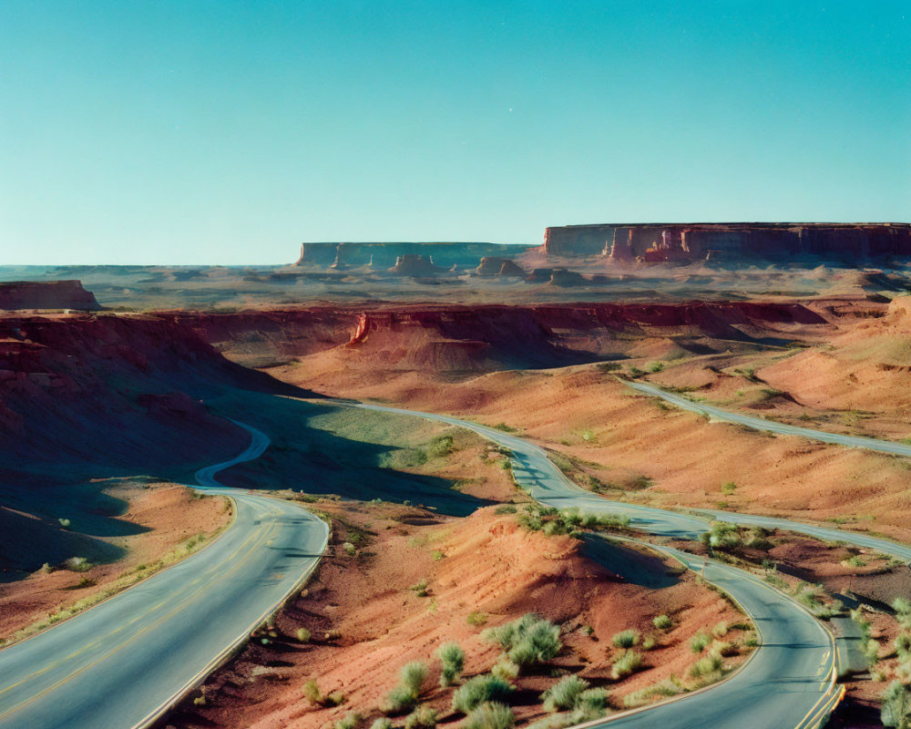 Barren Desert Landscape with Winding Road and Red Mesas