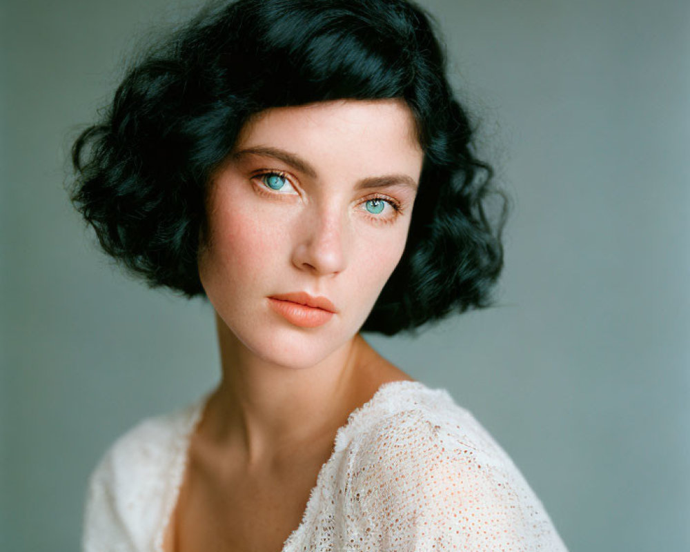Woman with Short Curly Black Hair and Blue Eyes in Dotted Blouse