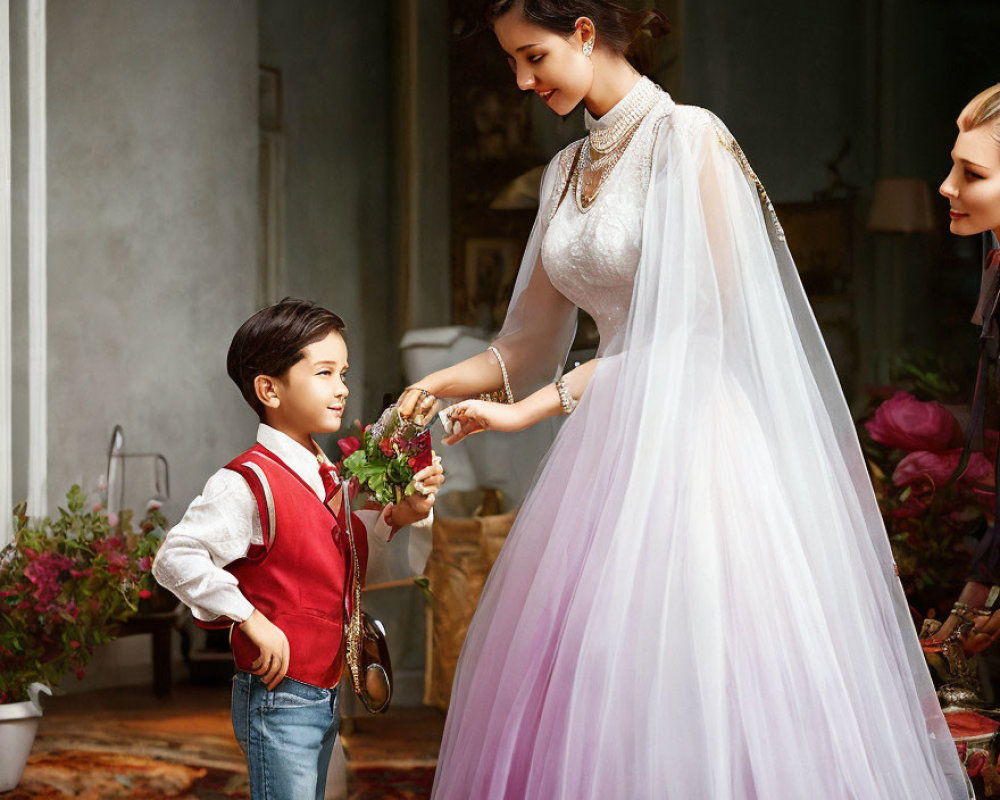Young boy in red vest offers flower to smiling woman in white wedding dress, observed by another woman