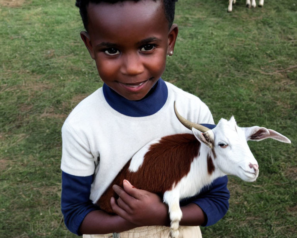 Curly-Haired Child Smiling with Goat in Grass Field
