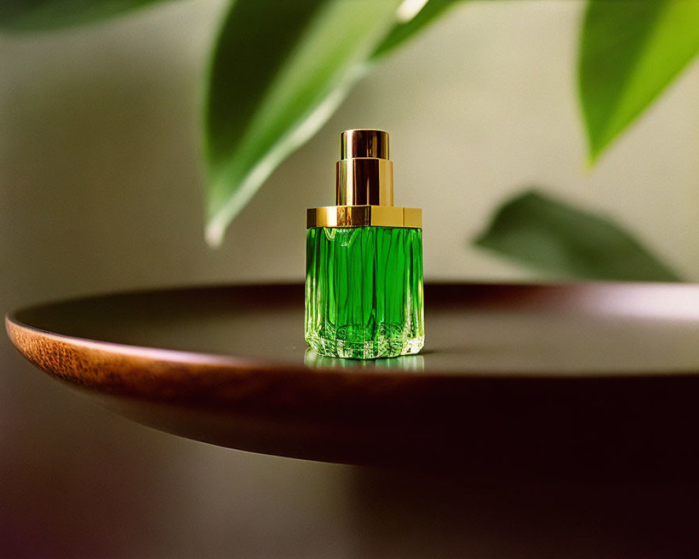 Green perfume bottle with gold cap on wooden surface surrounded by blurred green leaves
