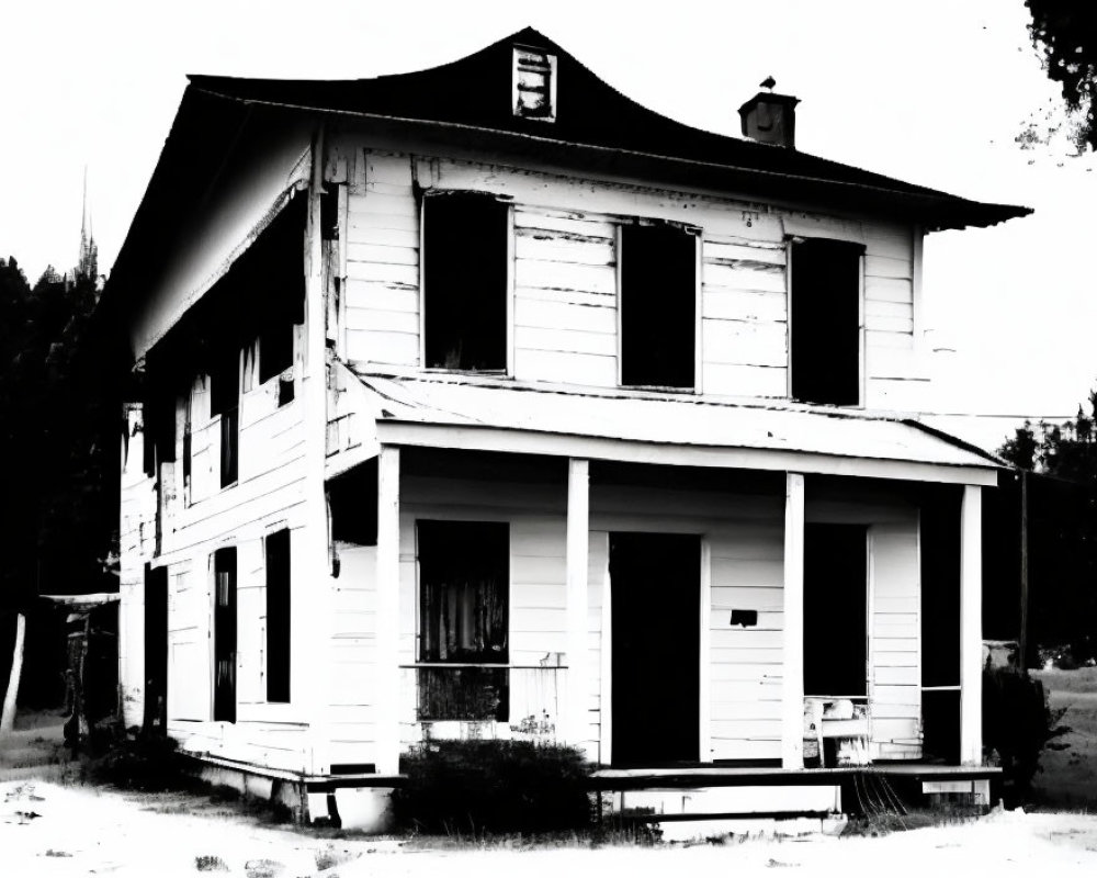 Dilapidated two-story house with boarded-up windows in monochrome.