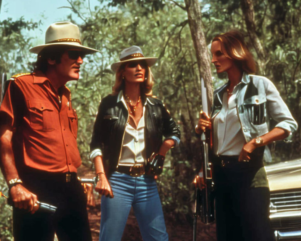 Three people in cowboy hats by car with shotgun