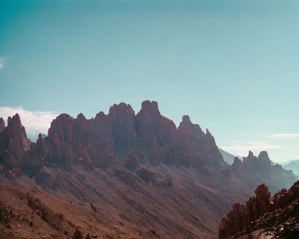 Majestic mountain peaks under clear blue sky and wispy clouds