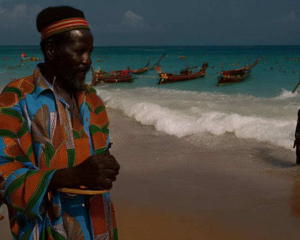 Elderly man in colorful shirt on beach with boats, young person in the surf