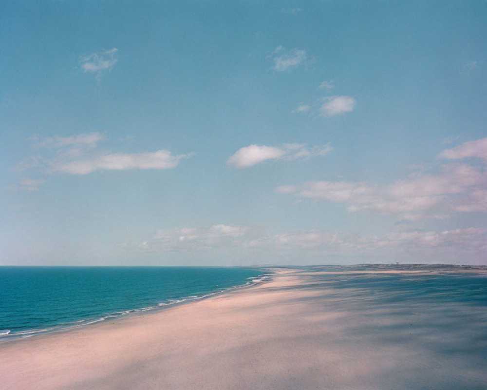 Tranquil Coastal Landscape with Sandy Beach and Calm Blue Ocean