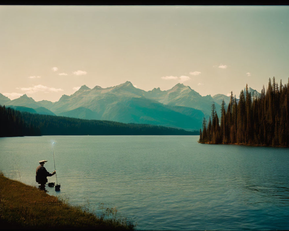 Tranquil lake fishing scene with distant mountains