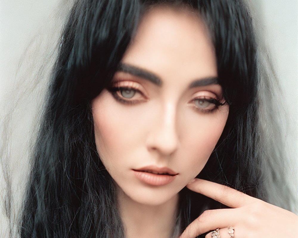 Dark-haired woman with smoky eye makeup and ring on finger