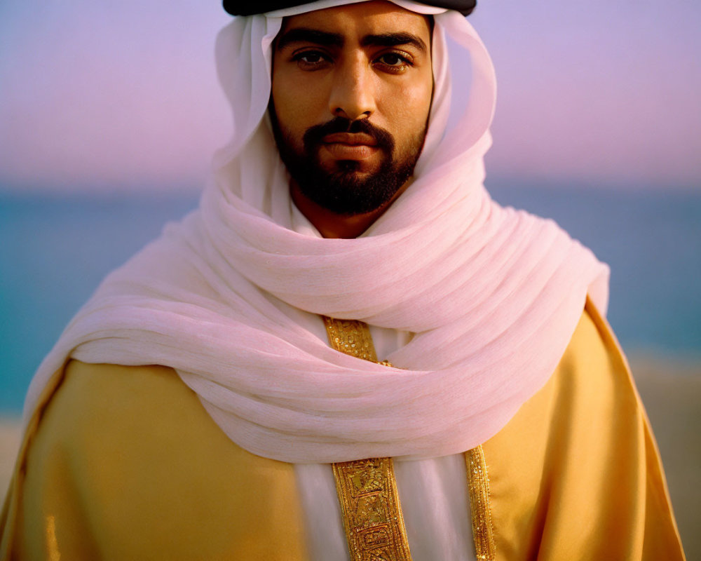 Traditional Arabic attire: Man in white headscarf and gold-trimmed robe