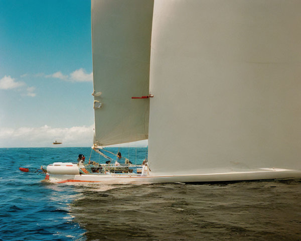 Sailboats racing with active crews on sunny blue waters