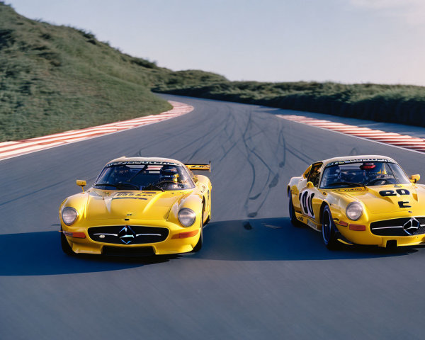 Vintage Racing Cars Speeding on Track with Black Stripes
