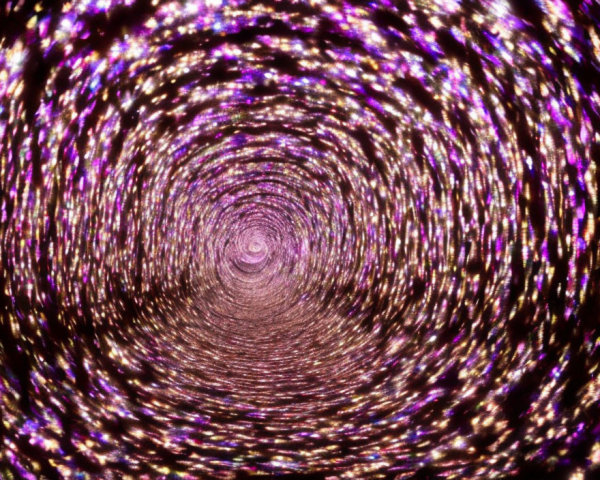 Sparkling Purple and Pink Light Spiral on Dark Background