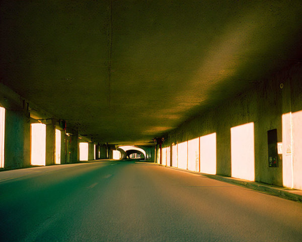 Empty underpass illuminated by sunlight shadows and warm glow