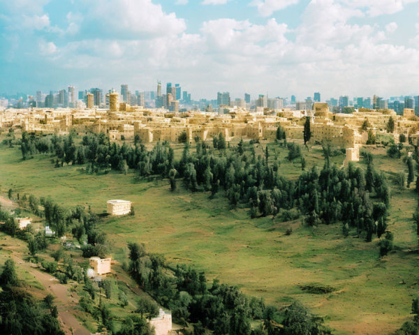 Panoramic cityscape with traditional and modern buildings among greenery